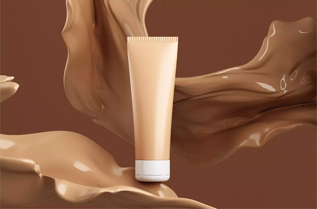 Beige cosmetic tube surrounded by swirling brown liquid against a matching background.